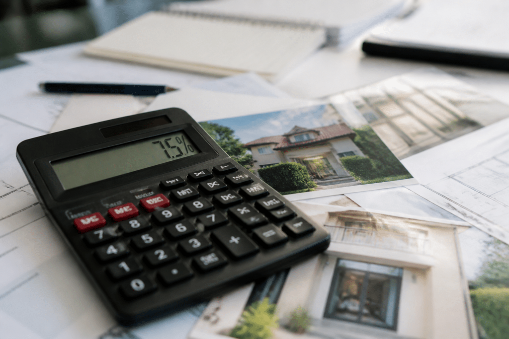 Calculatrice affichant pourcentage sept virgule cinq sur documents immobiliers
