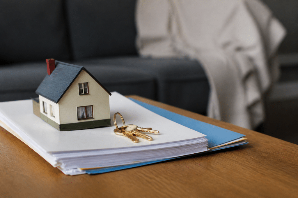 Maison avec clés dorées et documents de vente immobilière