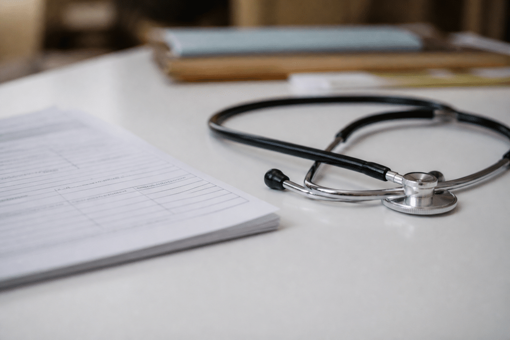 Formulaires medicaux et stethoscope sur bureau blanc