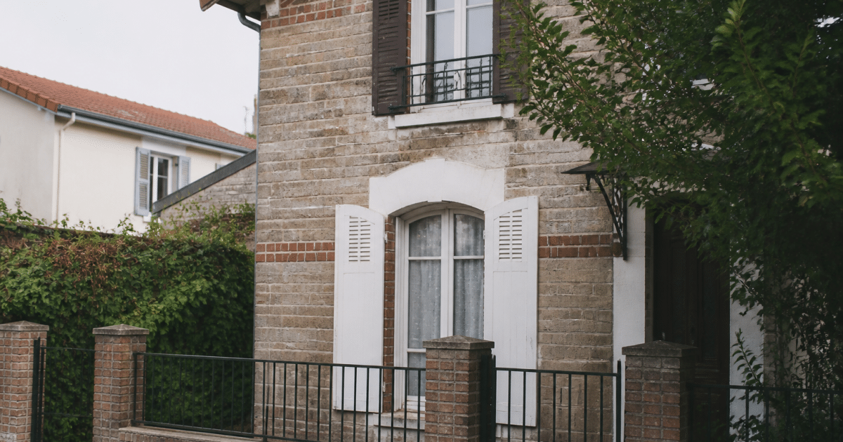 Maison avec panneau vendu suspendu devant facade