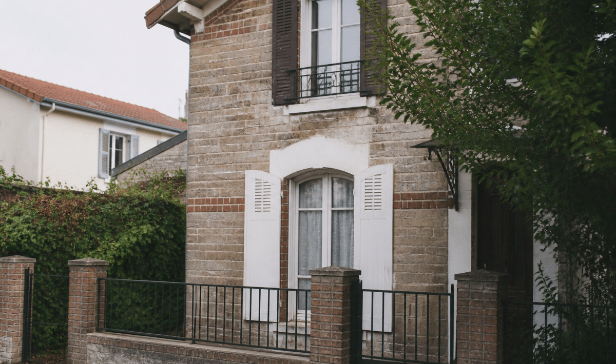Maison avec panneau vendu suspendu devant facade