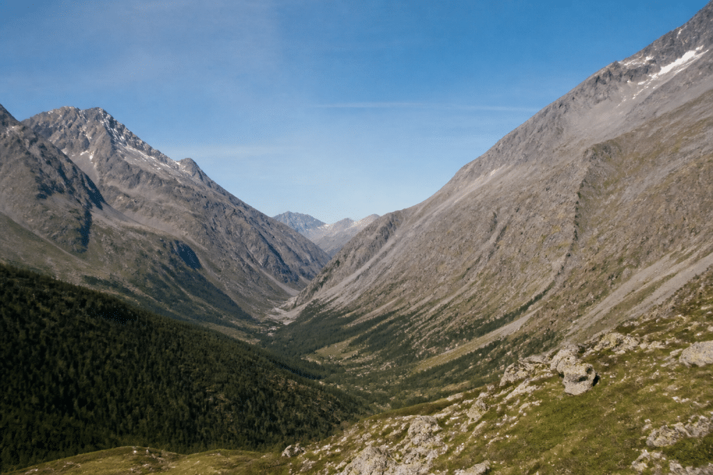 Montagnes escarpees et vallees isolees sous ciel bleu