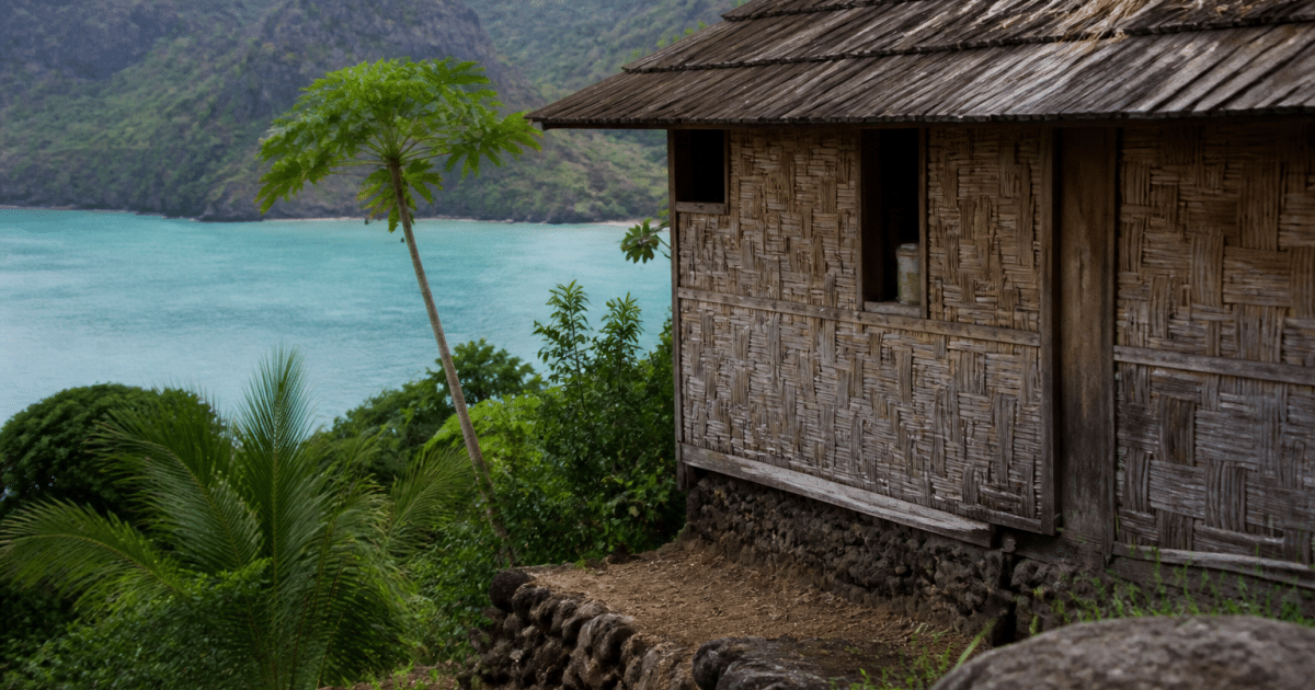 Maison polynésienne traditionnelle surplombant lagon turquoise Nuku-Hiva