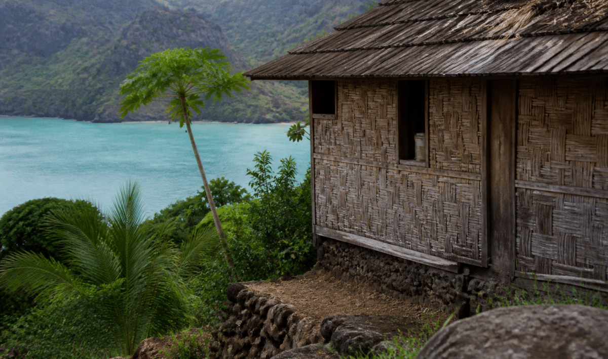 Maison polynésienne traditionnelle surplombant lagon turquoise Nuku-Hiva