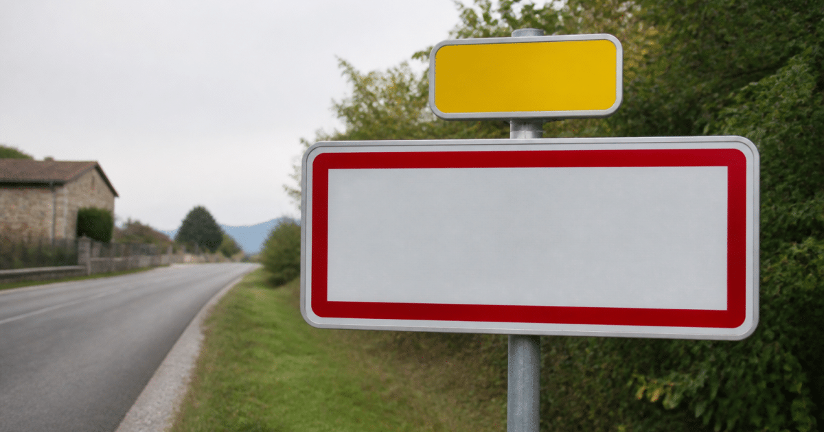 Panneau routier affichant le nom de la commune avec population inscrite