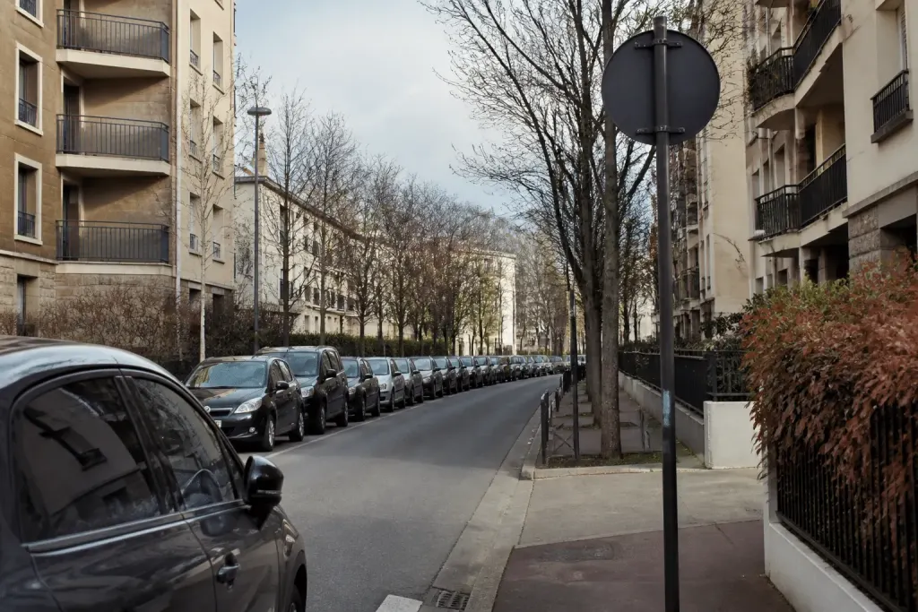 Rue urbaine avec immeubles résidentiels et panneaux de signalisation routière