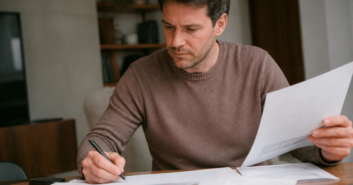 Homme assis à bureau examinant documents immobiliers réduction fiscale