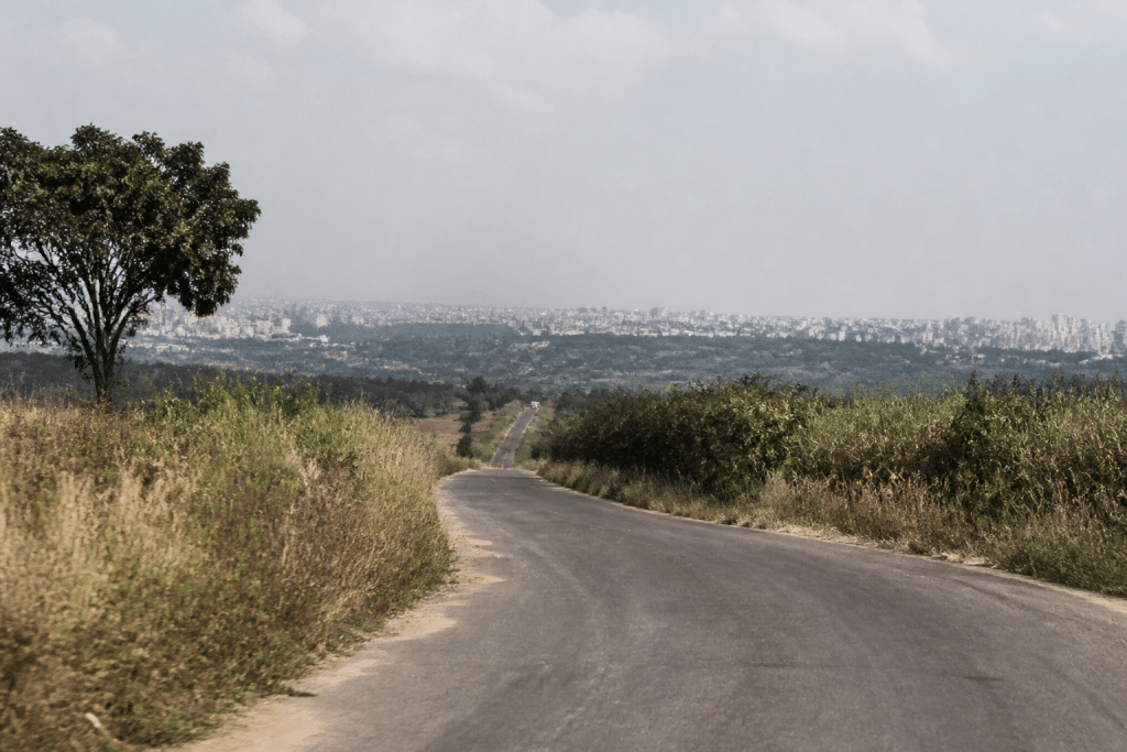 Terrain rural vide avec route menant vers ville lointaine